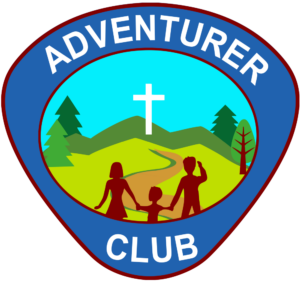 The adventurer club logo. The outline of the logo is a rounded triangle. Text along the top of the logo says, "Adventurer." Text along the bottoms says, "Club." There is a picture in the middle of the logo which includes a child holding hands with and standing between two adults. They are looking on a winding path that leads to a cross. The cross is on some hills and there are trees on either side of the hills.